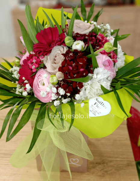 Bouquet con fiori assortiti in contenitore con acqua. Possibile indicare tonalità preferita.